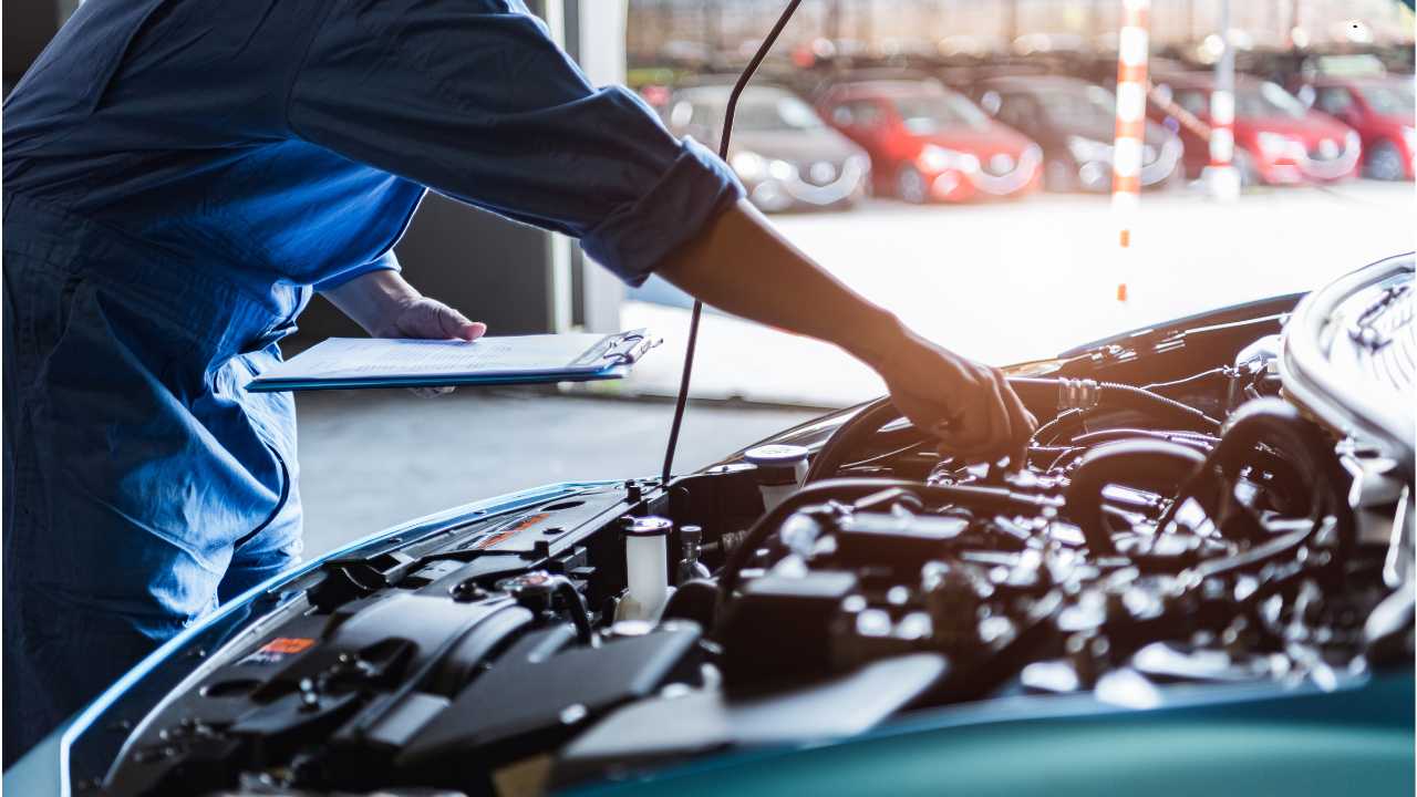 Mechanic repairing car with second-hand parts